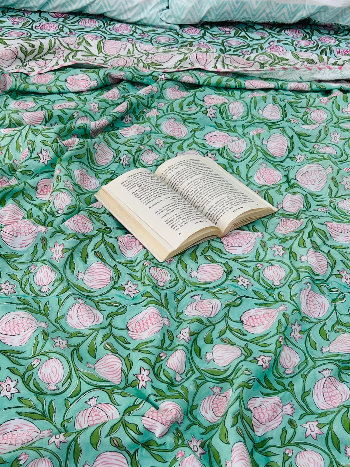 Green floral handblock printed muslin cotton dohar styled on a bed
