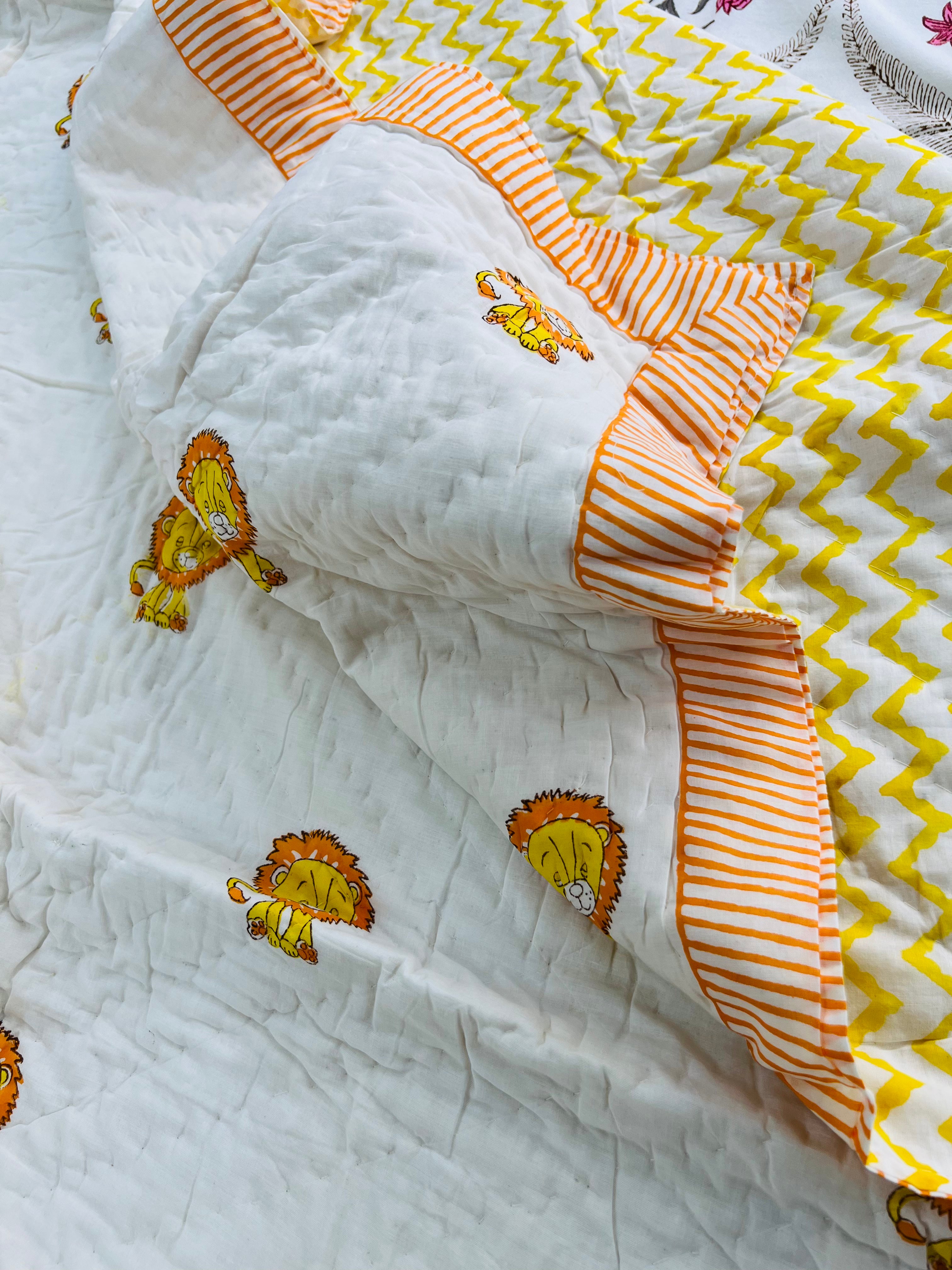 Close-up of a baby blanket with orange and yellow patterns on a white background