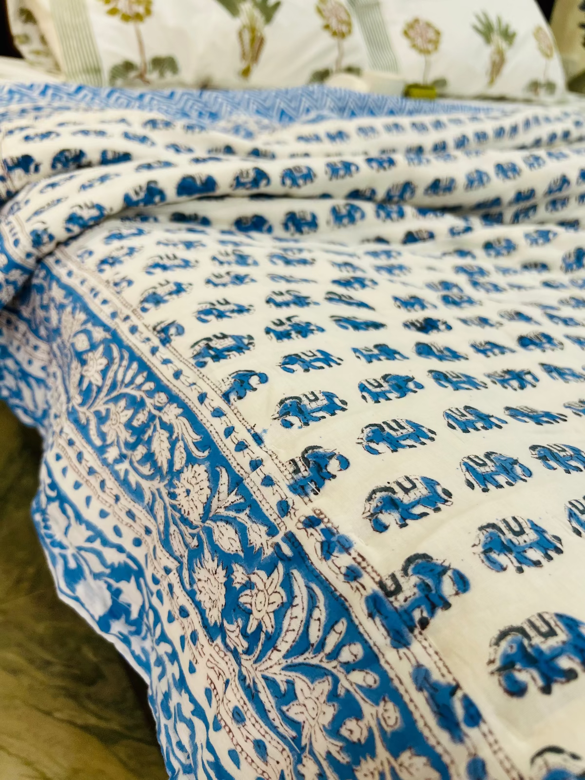 Blue and white patterned quilt on a bed