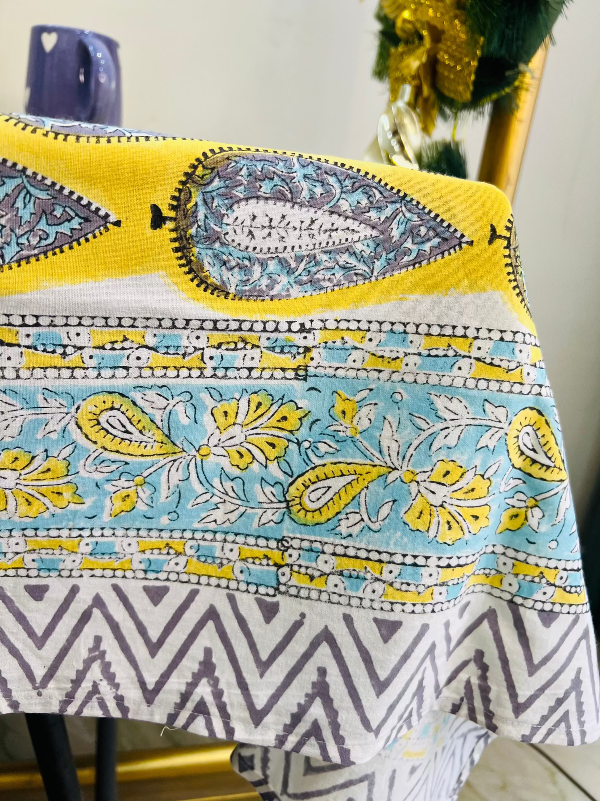 Colorful patterned tablecloth with geometric and floral designs on a table.