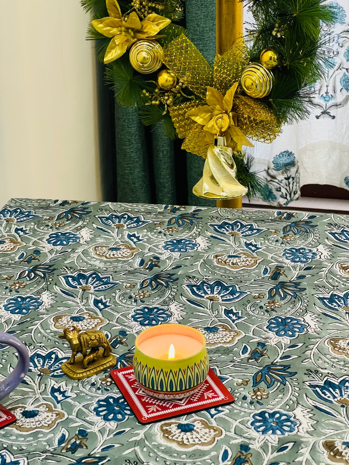 Decorative table setting with a floral tablecloth, candle, and festive decorations.