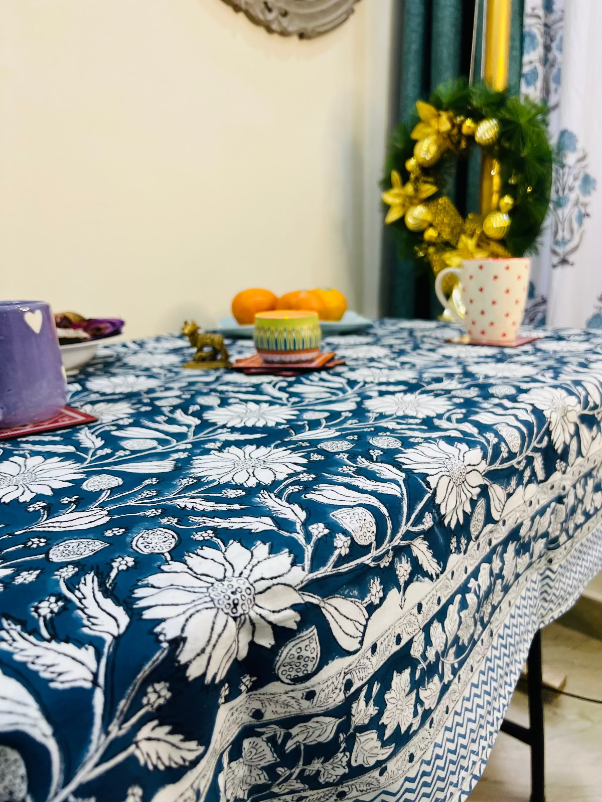 Tablecloth with floral pattern on a table set with cups and fruits