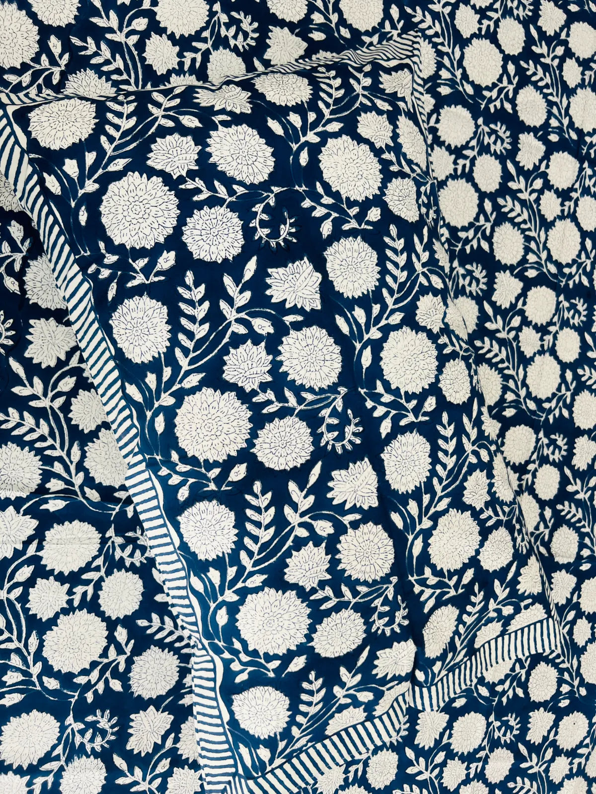 Close up of blue floral handblock printed cotton bedsheet fabric